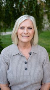 Woman with straight blonde hair in sweater.