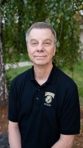 Man in black polo shirt outdoors.