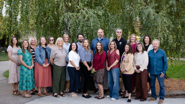 Group of people posing together outdoors.
